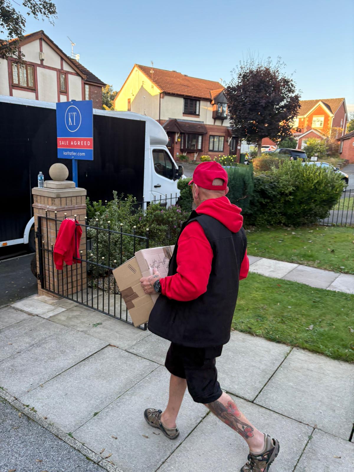 Removal porter taking boxes back to the van for loading