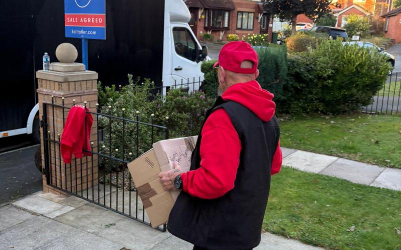 Removal porter taking boxes back to the van for loading