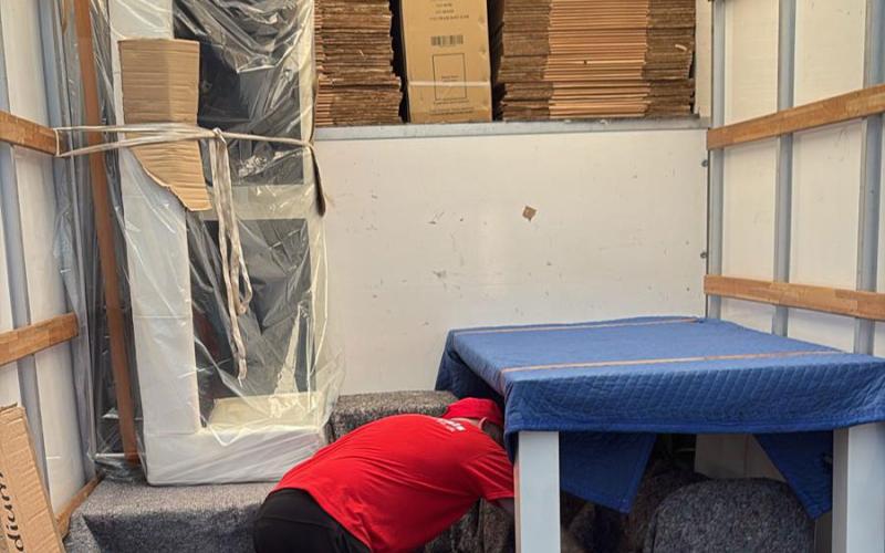 team packing up van and protecting furniture